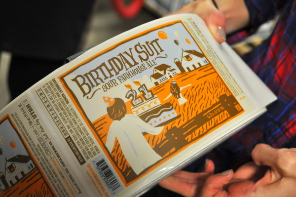 Uinta Marketing Director, Lindsay Berk, unveils the 21st Birthday Suit Sour Farmhouse Ale bottle label (Photo credit: Erika A. Brown)